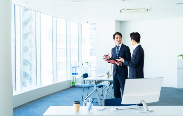 パンフレットデザインと印刷について相談する企業担当者