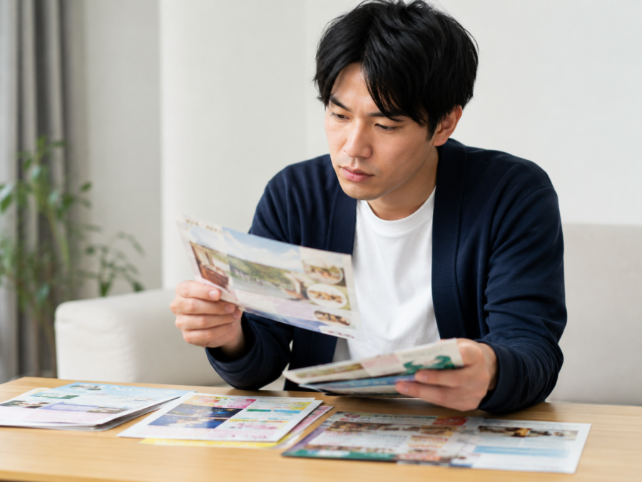 複数のチラシを手に取り内容を確認する男性