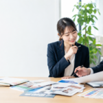 チラシのデザインと紙面構成を打ち合わせする企業担当者