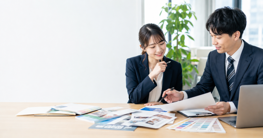 チラシのデザインと紙面構成を打ち合わせする企業担当者