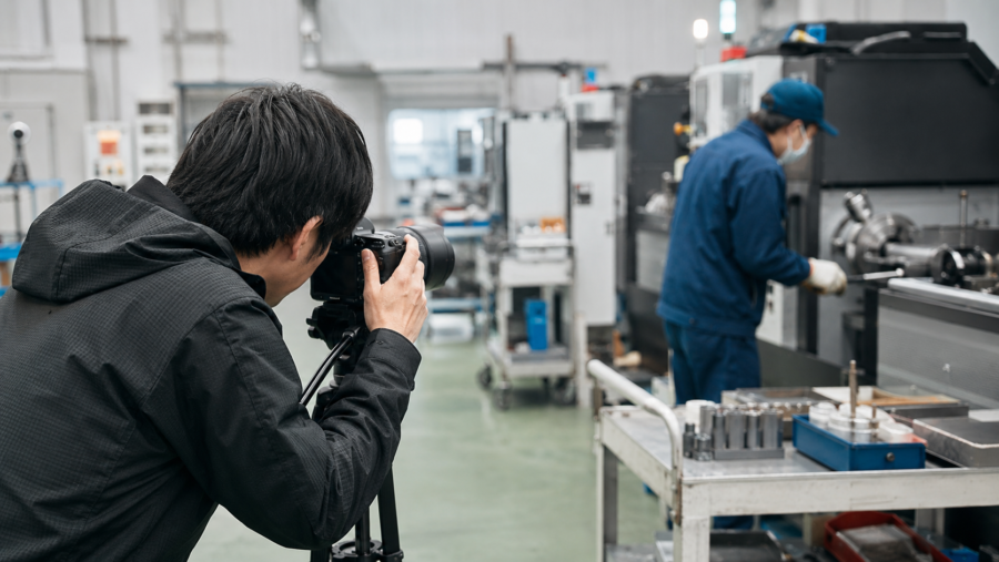 製造工場で設備と作業風景を撮影するカメラマン