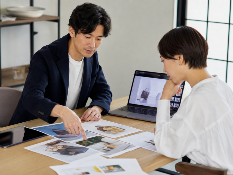 商品撮影の写真を確認しながら打ち合わせする企業担当者