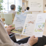 病院・クリニックの案内パンフレットを手に取って確認する患者のイメージ